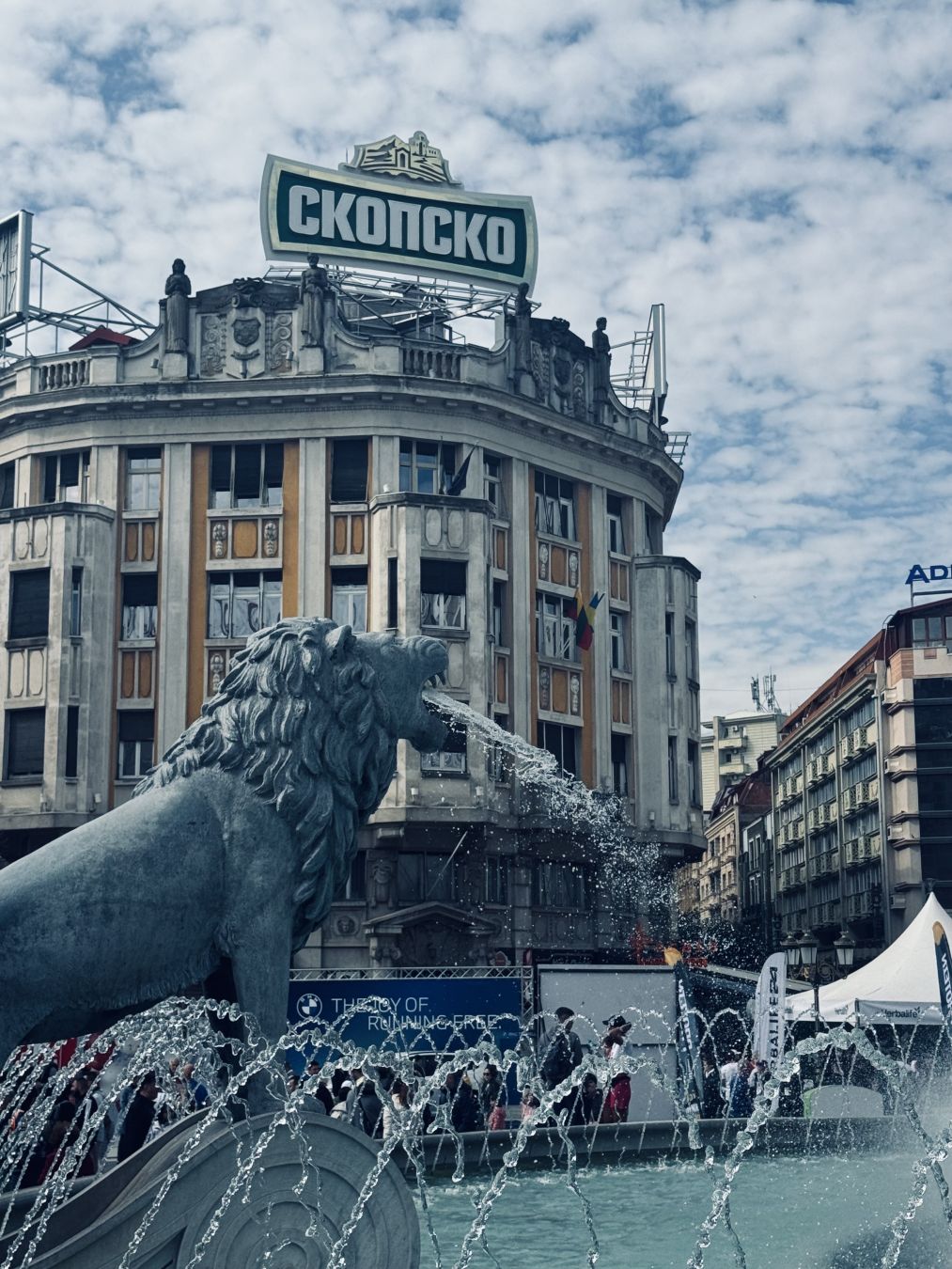 Water gushing lion fountain. Building in background.