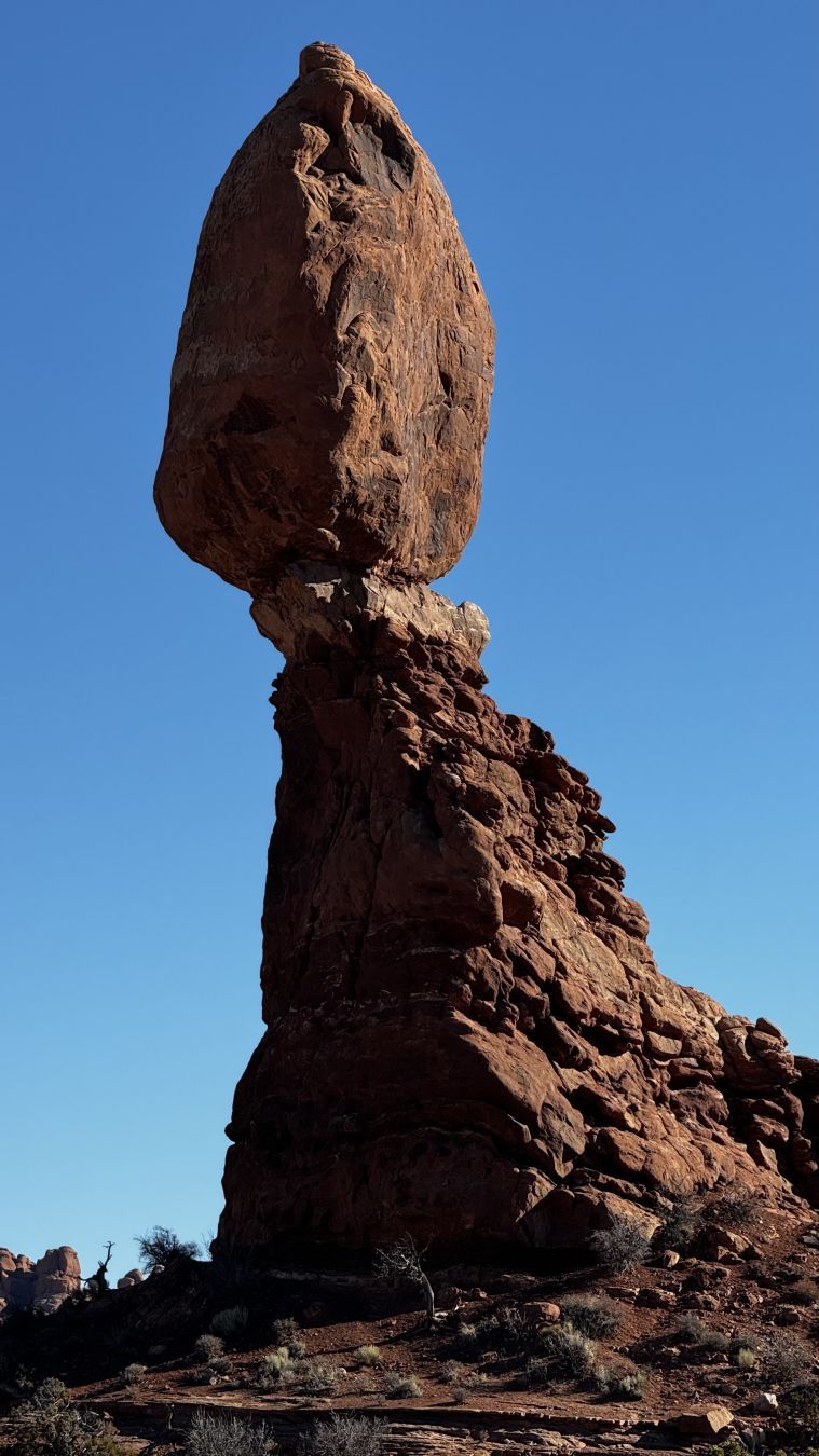 Photograph of Balancing Rock in Arches National Park, Utah. A huge massive rock balancing on a narrow pillar. Worn down by wind and rain it will one day fall.