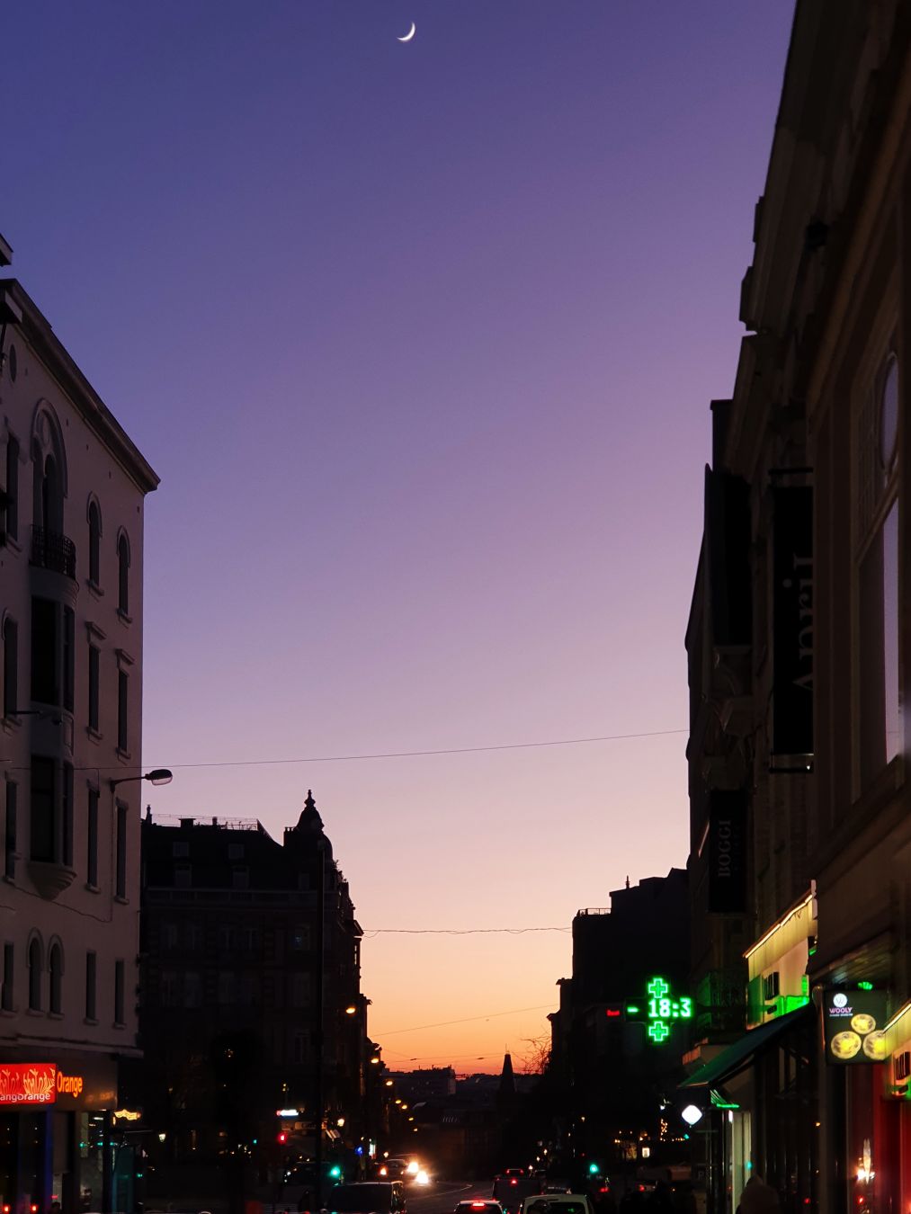 Skyline of Brussels in the evening, looking down a busy street.